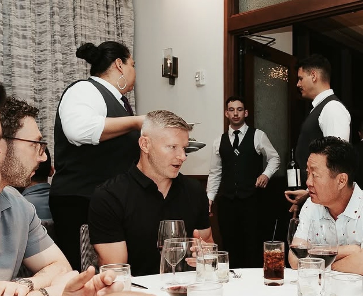 The founders deep in conversation over dinner with people from across the card-breaking community